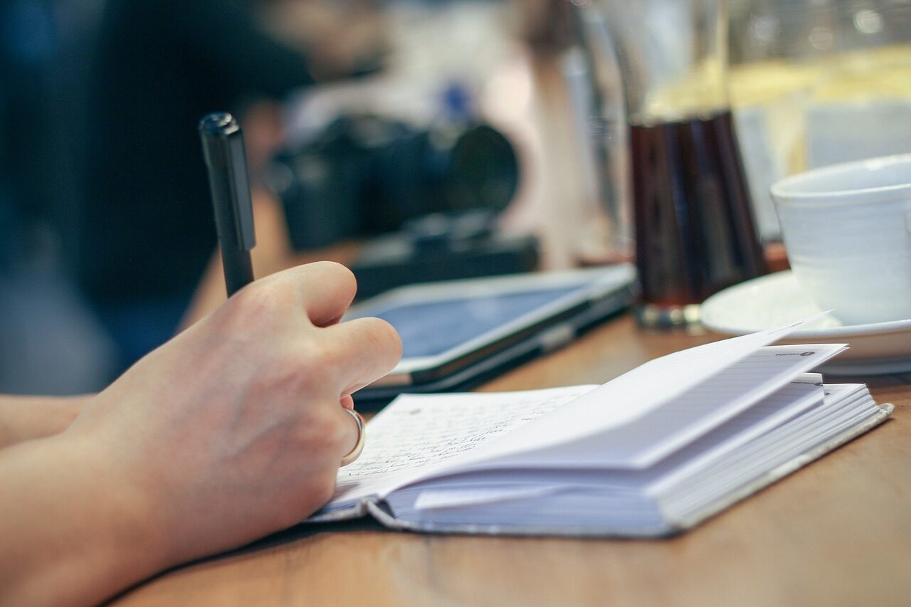 Arbeitsplatz mit Notizbuch und Kaffee